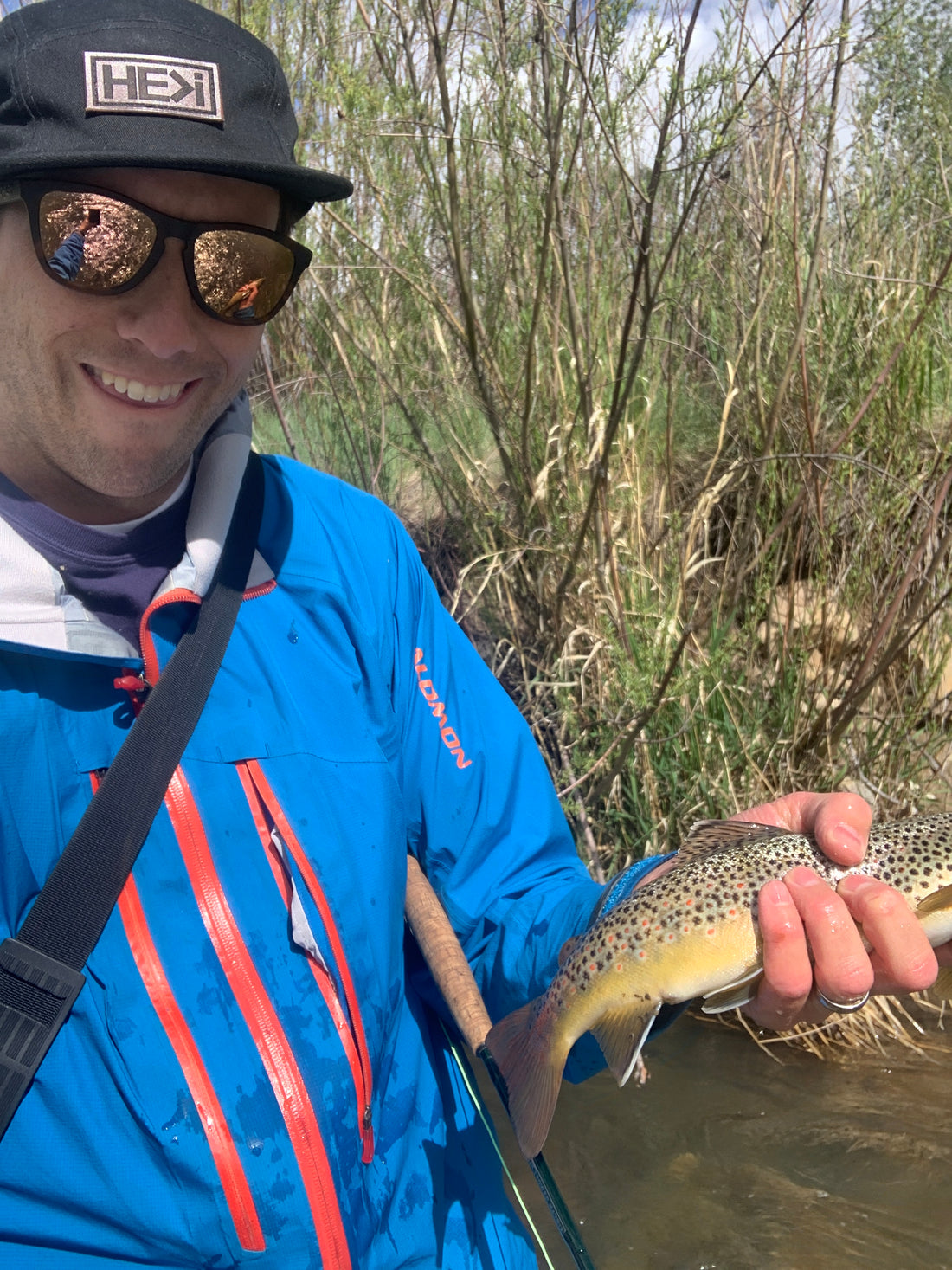 Fishing rod in armpit while holding fish 